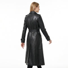 Woman wearing a black leather trench coat on a white background