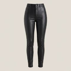 Female model wearing fitted black leather pants styled with a white tank top and black heels.
