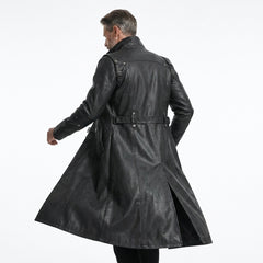Male model wearing a long black leather gothic coat with front zipper, waist straps, metal hardware, and sleek boots.