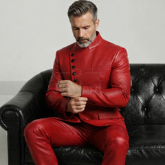 Man in a red leather suit sitting on a black leather couch.