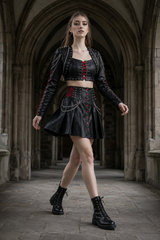 Side view of black gothic leather skirt set for women featuring punk bolero jacket, red lace-up waist, studded details, and chain accents