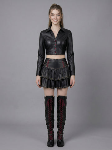 woman wearing black gothic leather skirt set with cropped top jacket and studded mini skirt