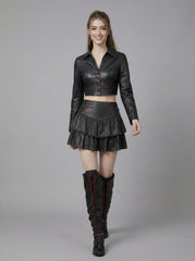 woman wearing black gothic leather skirt set with cropped top jacket and studded mini skirt