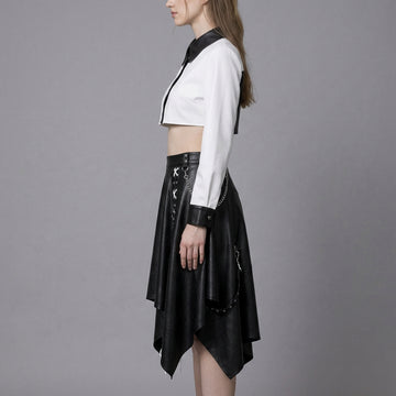 woman wearing black and white leather two-piece skirt set with crop top and handkerchief-hem skirt.