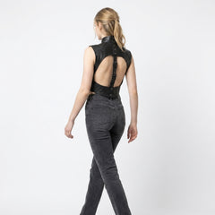 Women’s black leather chest harness vest featuring a bolero silhouette, metal snap buttons, and sculpted seam lines.