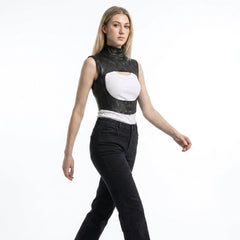 Woman wearing a black leather vest over a white top and black pants on a white background