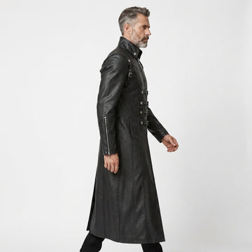 Man wearing a black leather gothic coat with silver buckles on a white background