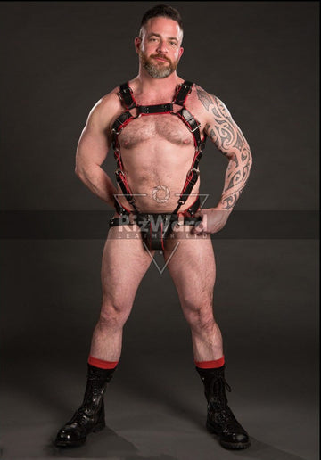 Man wearing a full body harness BDSM outfit in black and red with sexy jockstrap.