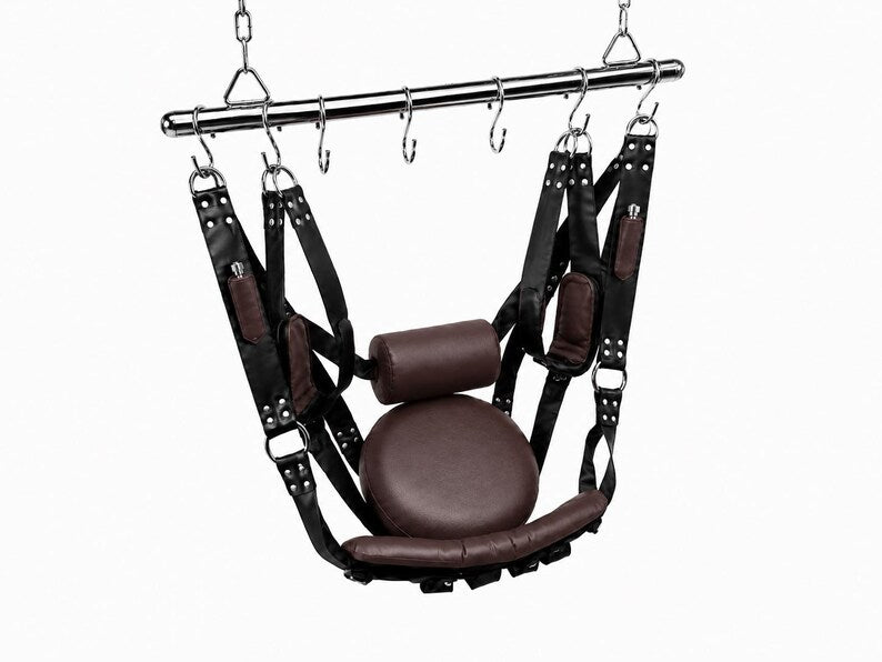 Black and dark brown leather sex swing shown hanging from a ceiling rod with padded seat and adjustable straps