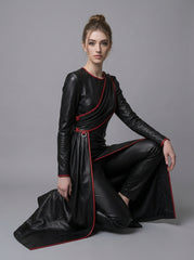 Seated model wearing black red leather gown with front slit, draped overlay, red trim, and dramatic fantasy gown styling - Rizwards Leather