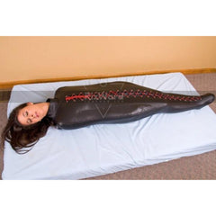 woman laying on mattress wearing a leather sleep sack -Sleepsack Bondage